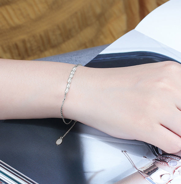 affordable tiny pear bracelet for women, women wearing a silver modern pearl bracelet